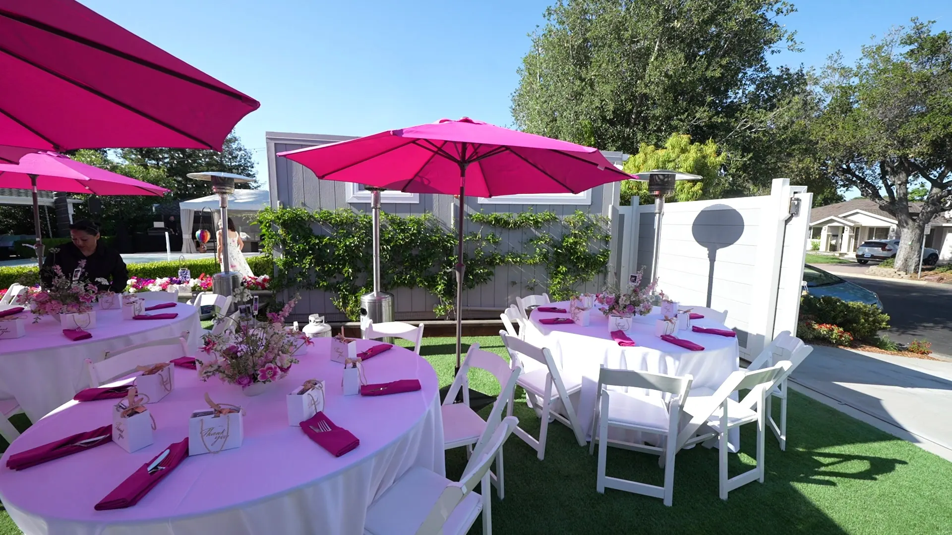 Umbrella-shaded party tables set across a backyard lawn at a San Rafael downtown office event
