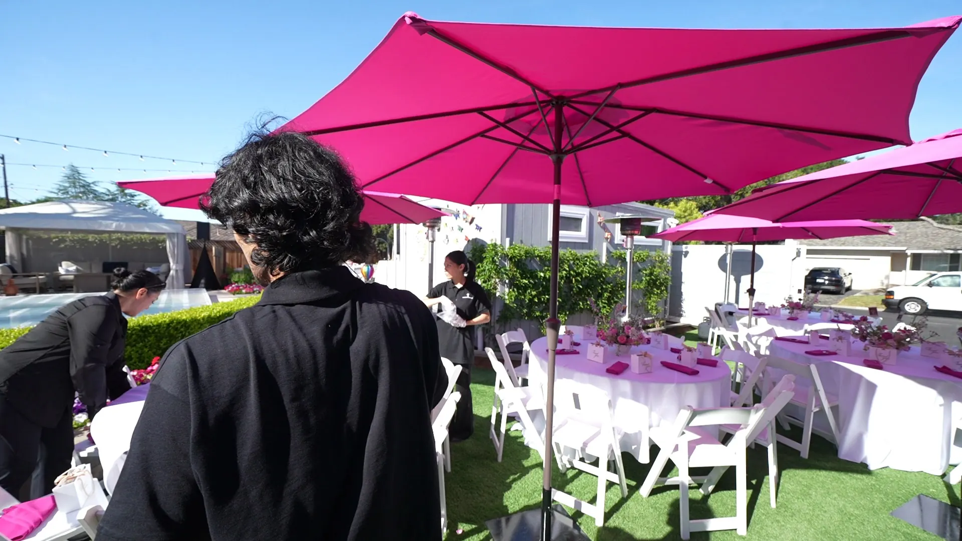 Attendant tending a patio buffet beneath a bright umbrella at a Santa Rosa wine-country reception