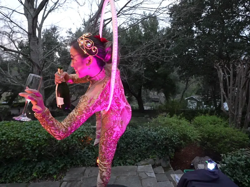 Costumed performer toasting guests in the garden at a Petaluma graduation celebration