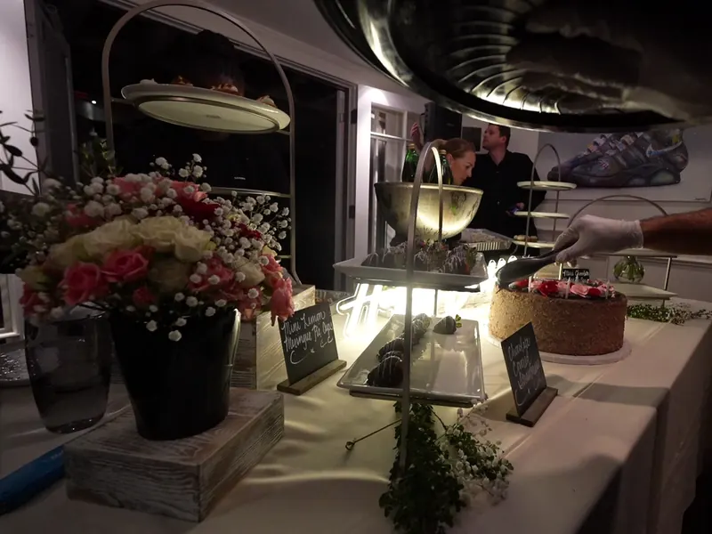 Buffet dressed with fresh florals and chalkboard menu signs at a San Rafael wedding reception