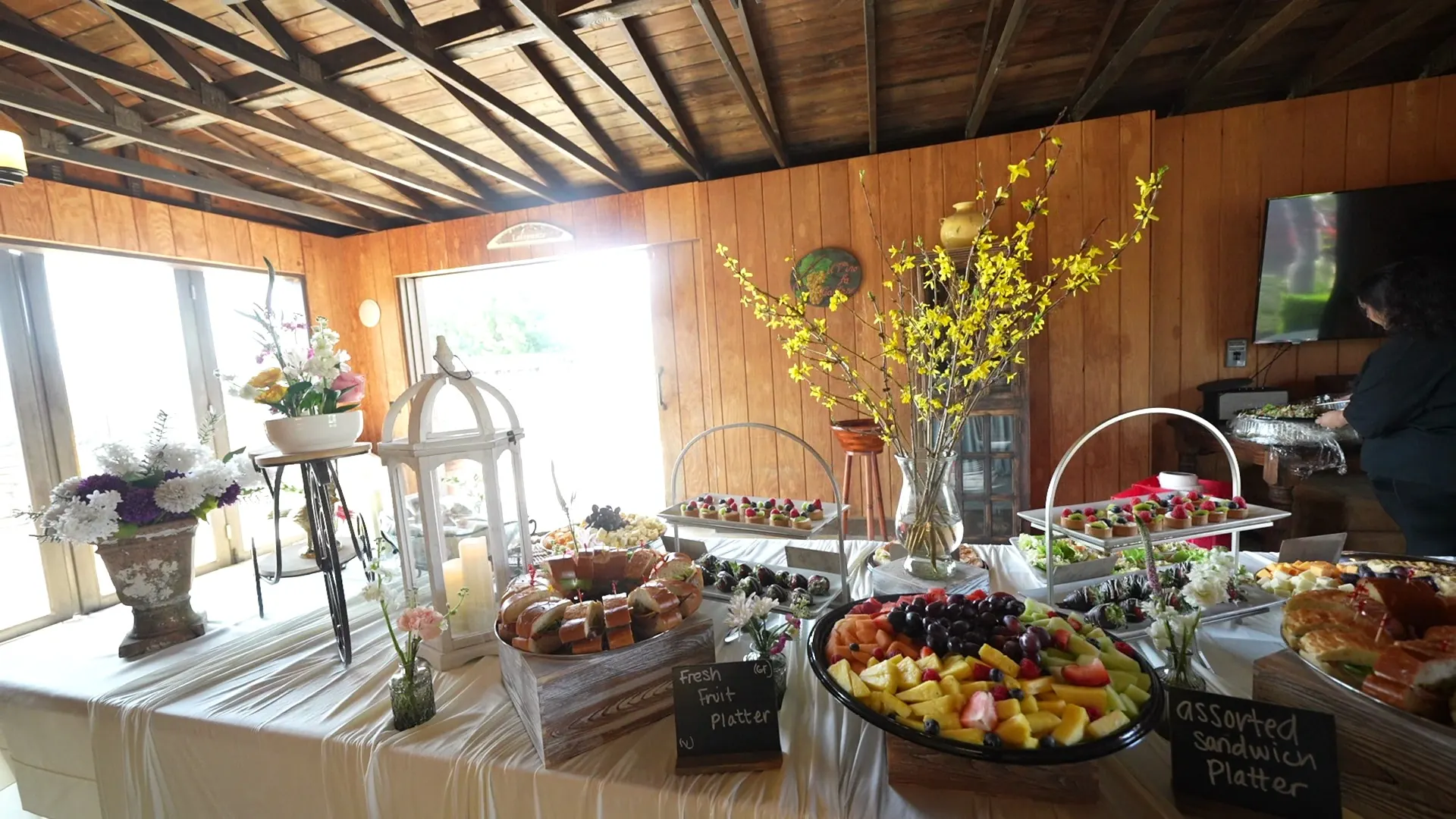 Rustic barn dessert and fruit display with spring branches at a Novato backyard barbecue party