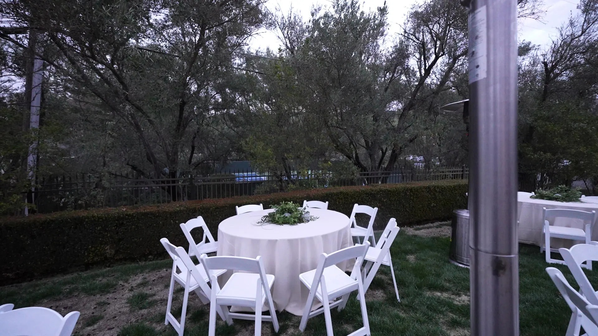 White-linen round table set under mature oaks at a Bodega coastal reception