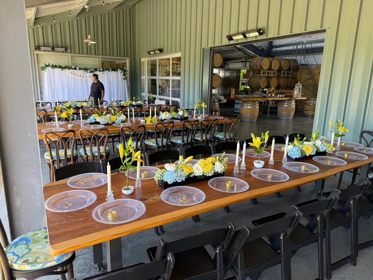Low in-house floral centerpieces with garden roses and greenery running down a dinner table at a Marin County wedding by Marin Catering Company