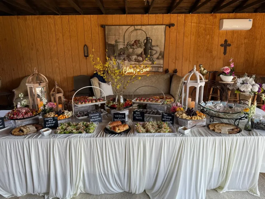 Abundant grazing table of cheeses, cured meats, seasonal fruit and crostini set for a cocktail hour in San Rafael by Marin Catering Company