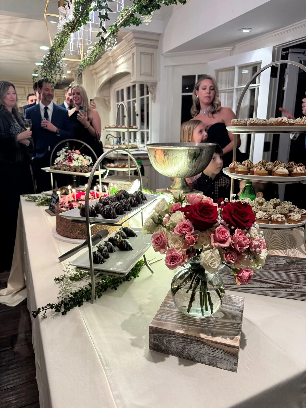 Wedding dessert display with cake, mini pastries and chocolate-dipped strawberries at a Tiburon reception by Marin Catering Company